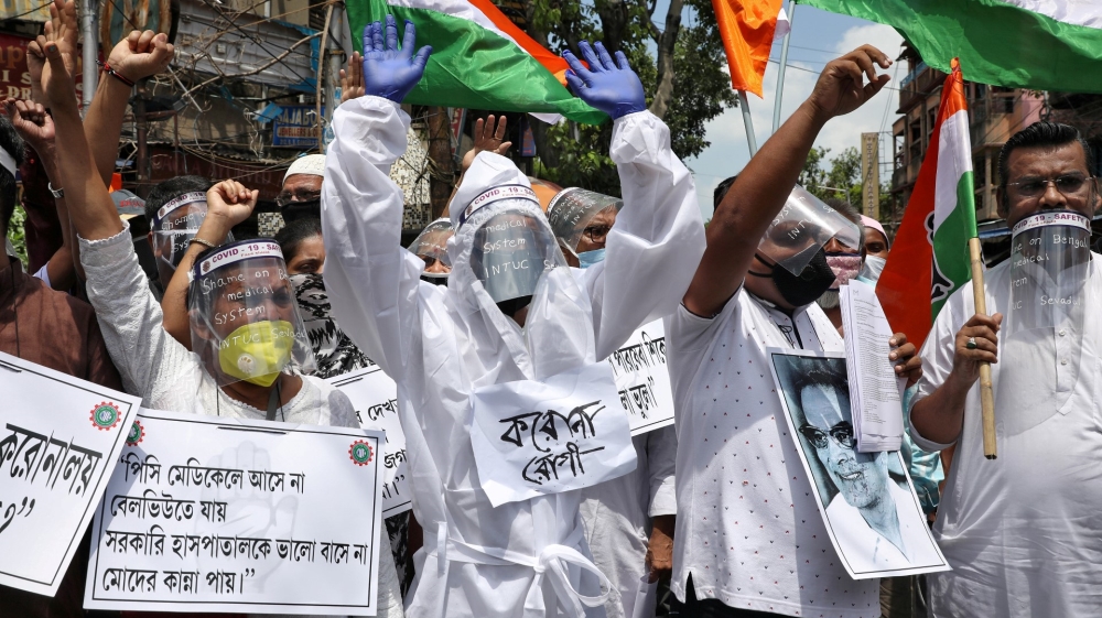 Supporters of opposition Congress party wearing protective gear attend a protest in Kolkata demanding better treatment for people infected with the coronavirus disease