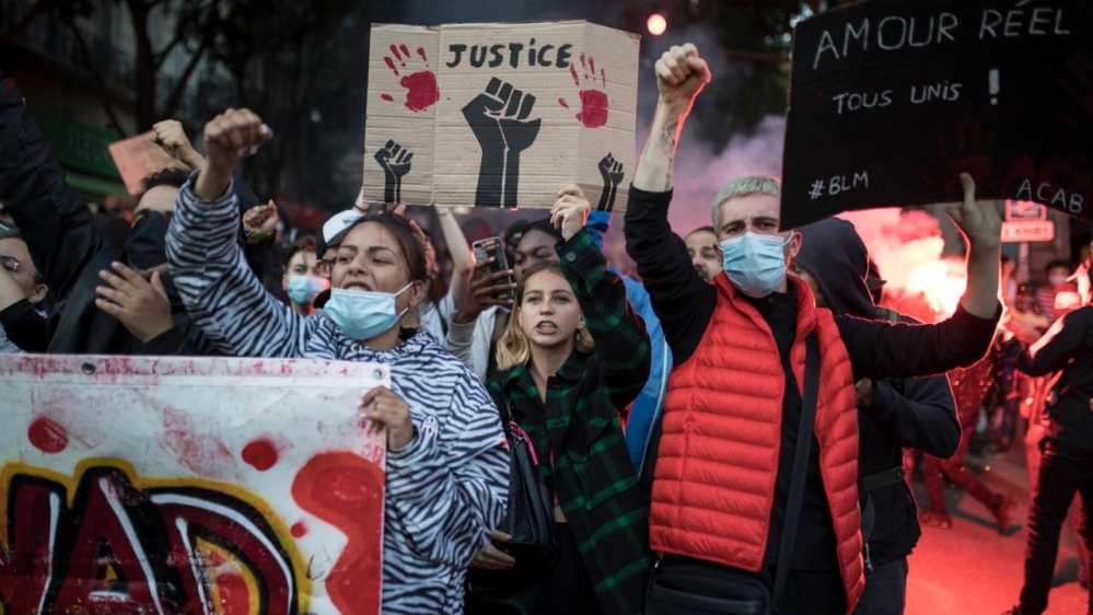 Protesters raise their fists during a march against police brutality and racism in Marseille, France