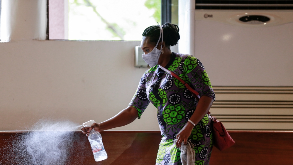 A worker sprays disinfectant on the chairs, after a church service as worship centers were reopened following the ease of restrictions imposed to curb the spread of the coronavirus disease (COVID-19) in Abuja