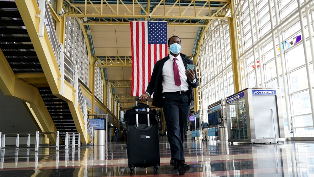 A passenger walks through Reagan National Airport in Washington, DC. Airlines are saying passengers could be banned if they refuse to wear a face mask