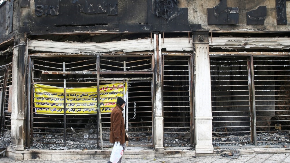 A man walks past the ruins of a burnt bank, after protests against increased fuel prices, in Tehran, Iran November 20, 2019. Picture taken November 20, 2019. Nazanin Tabatabaee/WANA