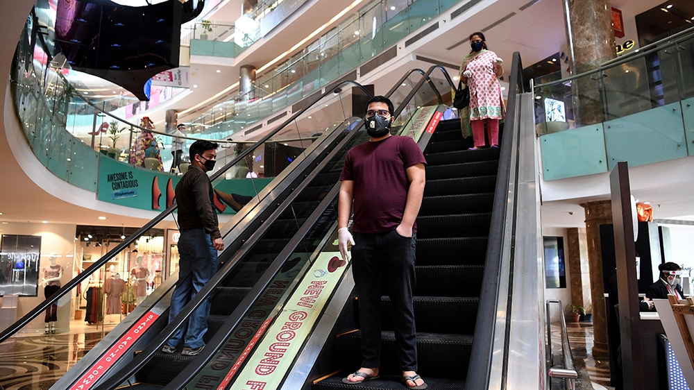 Visitors wear face masks at the Ambience Mall in capital New Delhi