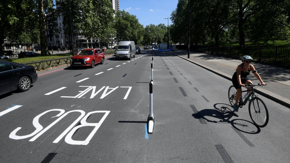 A cyclist rides along a newly created bicycle lane by Transport for London on Park Lane in London