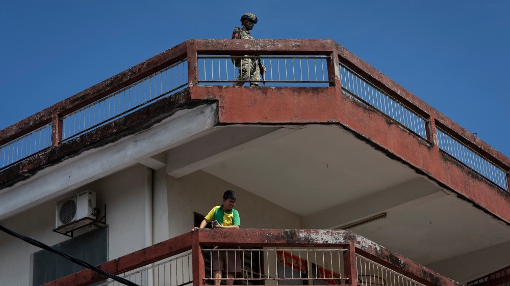 A soldier stands guard on a rooftop in Selayang Baru in Kuala Lumpur on May 3