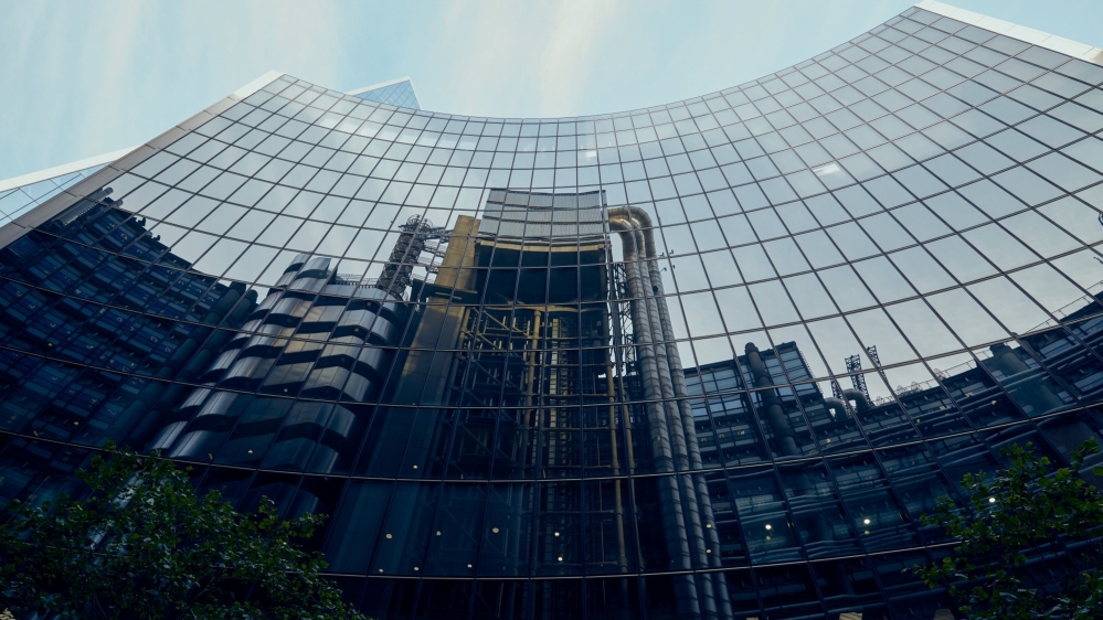 The Lloyds of London building is reflected in office windows