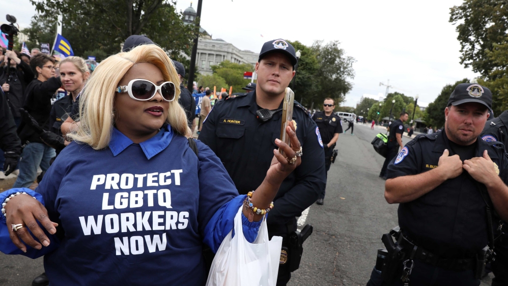 An LGBTQ activist taking a photo outside the US Supreme Court as it hears arguments in the major LGBT rights case on whether a federal anti-discrimination law that prohibits workplace discrimination on the basis of sex covers gay and transgender employees in Washington, US