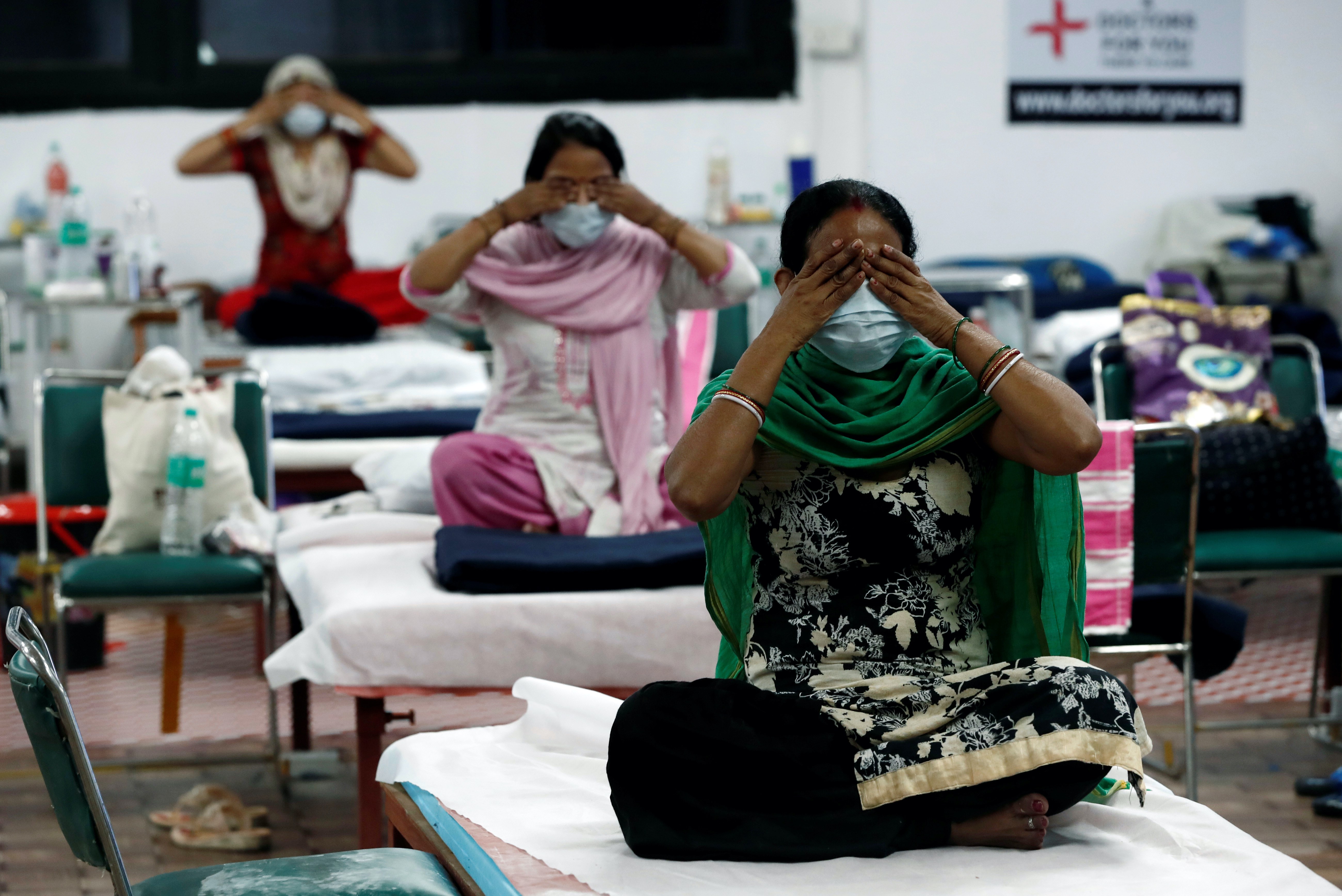 People suffering from the coronavirus perform yoga inside a care centre for patients in New Delhi, India