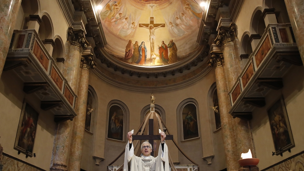 In this April 2, 2020 file photo, Don Angelo Riva celebrates a mass in an empty church in Carenno, Italy.