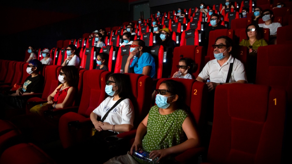 People wearing face masks to protect against the coronavirus watch the film Dolittle at a movie theatre in Beijing