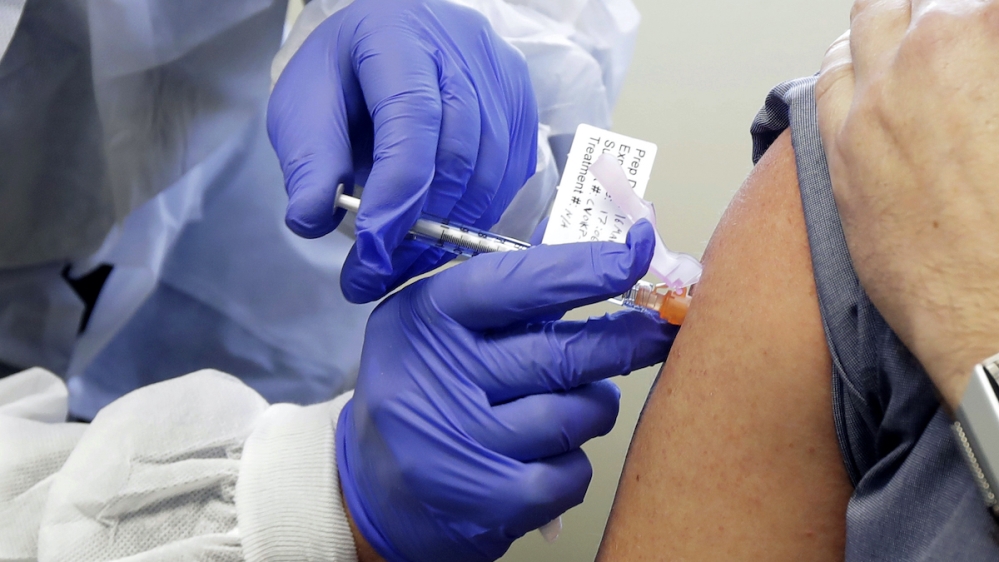 A person receiving a shot in a clinical trial of a potential vaccine for COVID-19 at the Kaiser Permanente Washington Health Research Institute in Seattle