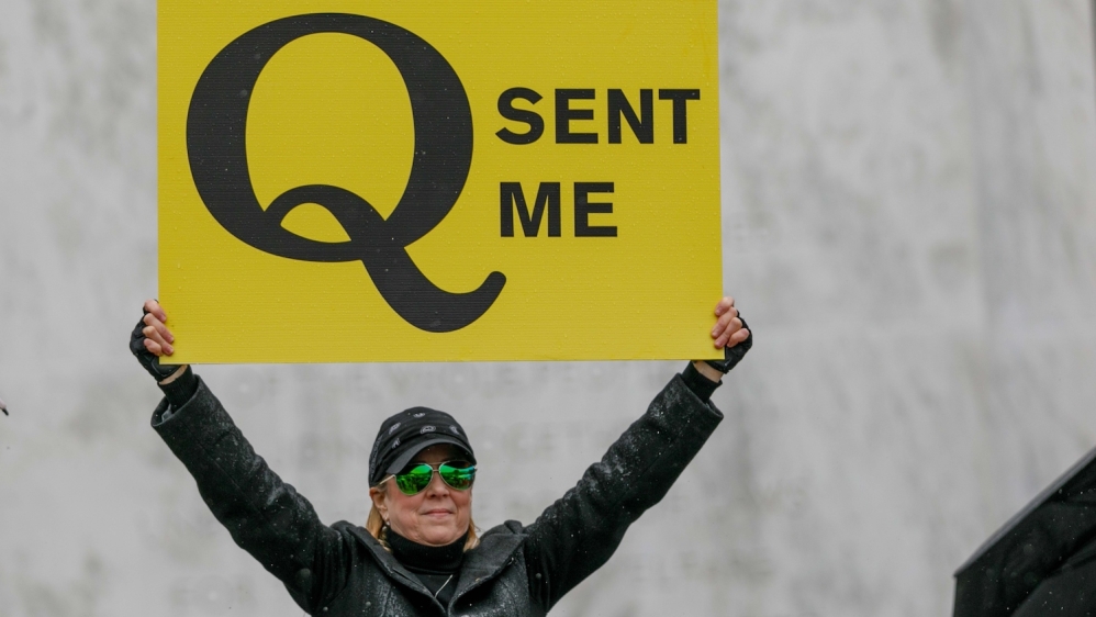 The QAnon conspiracy theorists hold signs during the protest at the State Capitol in Salem, Oregon, US on May 2, 2020