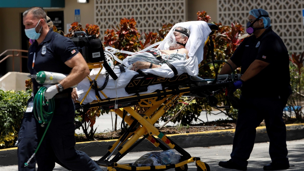 Emergency Medical Technicians (EMT) wheeling a patient to Hialeah Hospital where coronavirus disease patients are treated, in Hialeah, Florida, US