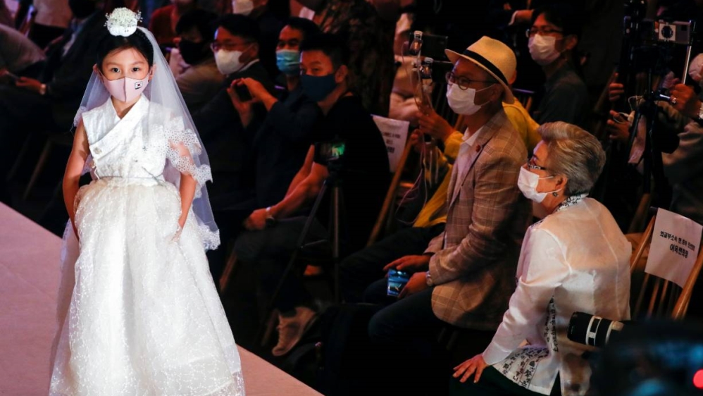 A child model presents a creation during a fashion show, wearing a mask as a measure to avoid the spread of the coronavirus disease, in Seoul on Friday