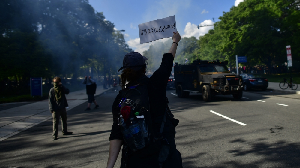 A protester holds a Black Lives Matter sign towards police shooting tear gas after a march through the Center City neighbourhood on June 1, 2020, in Philadelphia, Pennsylvania, in response to George Floyd’s death in Minneapolis, Minnesota while in police custody