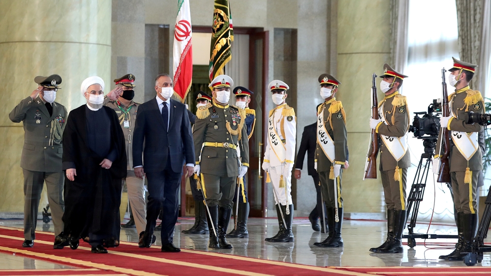 Iranian President Hassan Rouhani and Iraqi Prime Minister Mustafa al-Kadhimi walk during a welcome ceremony, as they wear protective masks, in Tehran, Iran, July 21 2020. Official Presidential website