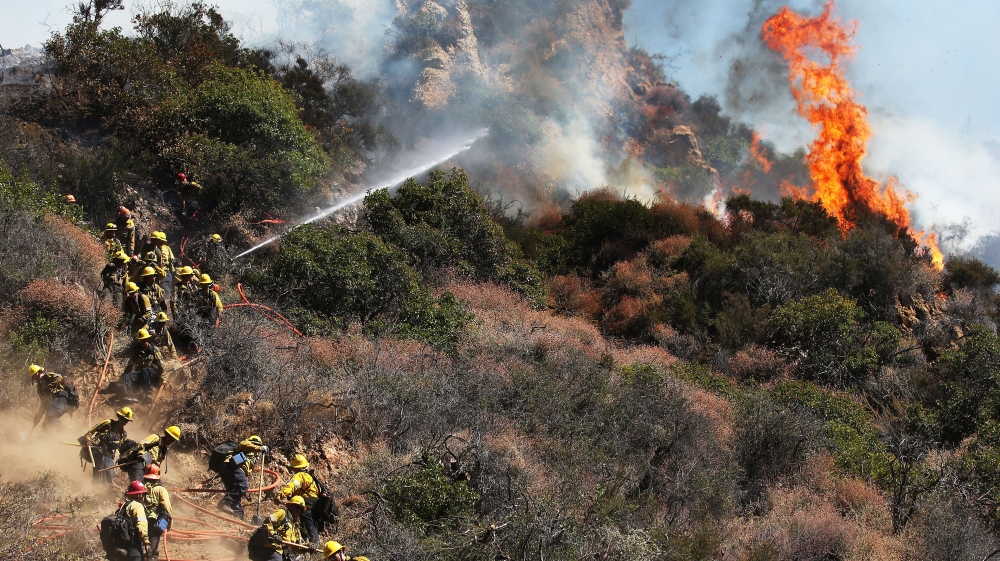 Firefighters tackle a wildfire threatening nearby hillside homes in the Pacific Palisades neighborhood of Los Angeles in 2019 [Getty Images]