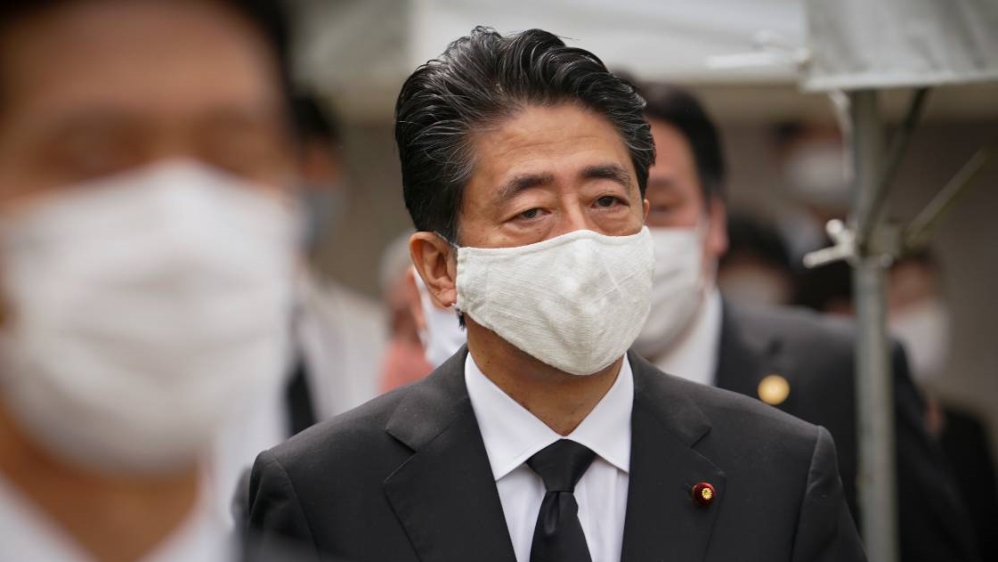 Abe says Japan will allow foreigners with residence status to enter the country from the start of next month [EPA]