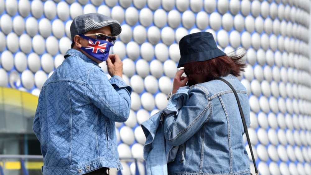 People wearing protective face masks are seen outside the Bullring shopping centre in Birmingham, central England, as the UK’s second city, was made an ‘area of enhanced support’, because of concern about a spike in cases