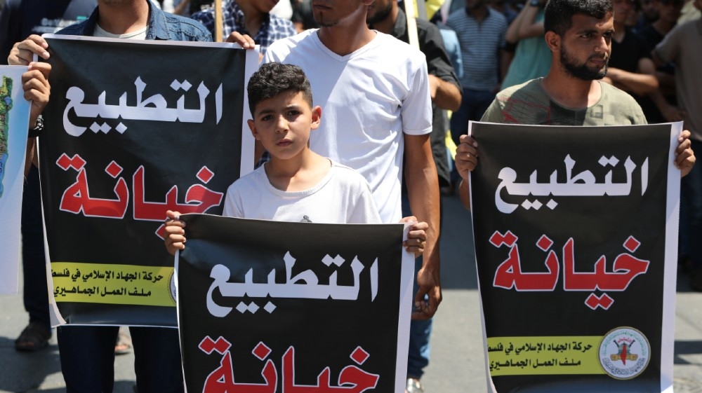 Palestinians hold banners reading "normalization is a treason" during a protest against the United Arab Emirates'' deal with Israel to normalise relations, in Gaza City August 14, 2020.