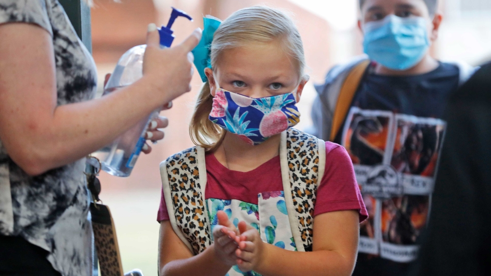 An elementary school student using hand sanitiser before entering school for classes in Godley, Texas