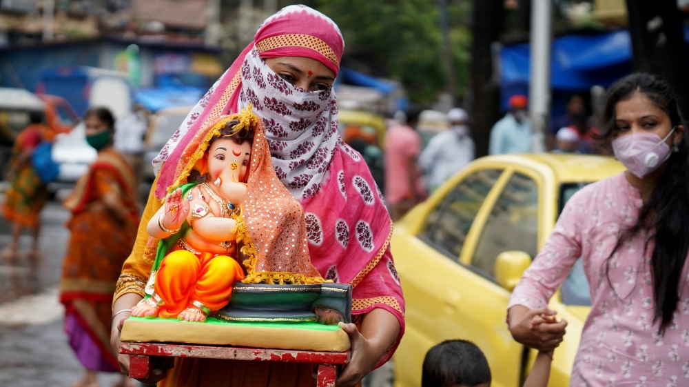 A woman carries an idol of Hindu God Ganesh to her home on the first day of the 10-day-long Ganesh Chaturthi festival, amid the coronavirus outbreak, in Mumbai, India