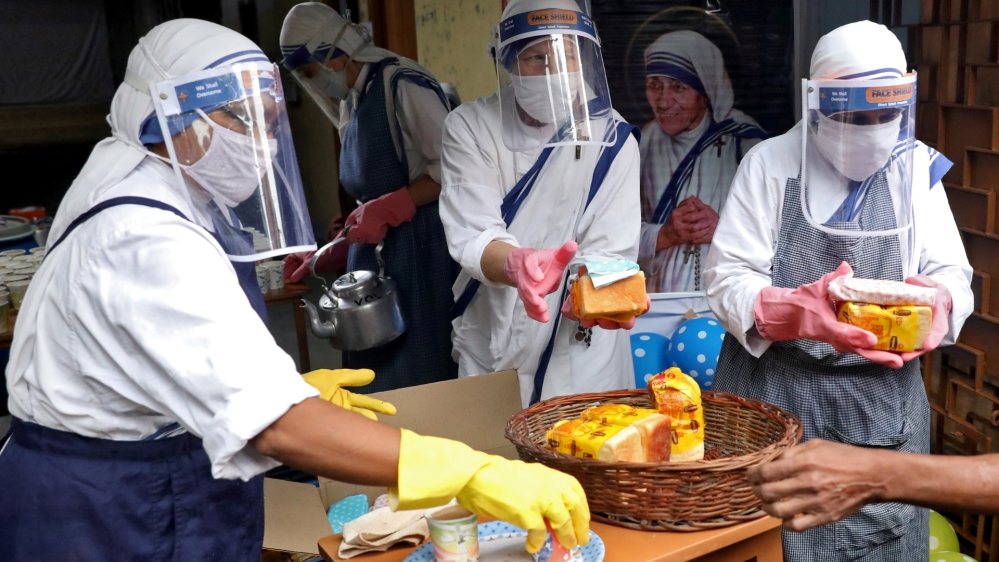 Catholic nuns from the Missionaries of Charity, the global order of nuns founded by Saint Mother Teresa, wear protective face shields as they prepare to distribute free snacks and tea among the poor in Kolkata, India