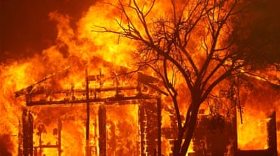 A burning home is seen along Cherry Glen Road during the LNU Lighting Complex Fire on the outskirts of Vacaville, California,