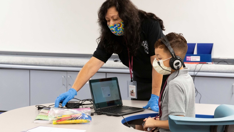 An instructional assistant helping a student at Wilson Primary School in Phoenix, Arizona, US