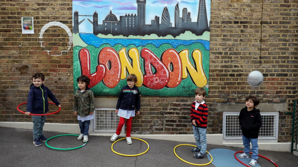 Children use hoops for physical distancing at an independent French bilingual school in Fulham, London