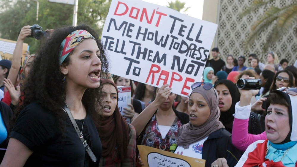 Women chant slogans as they gather to protest against sexual harassment in front of the opera house in Cairo
