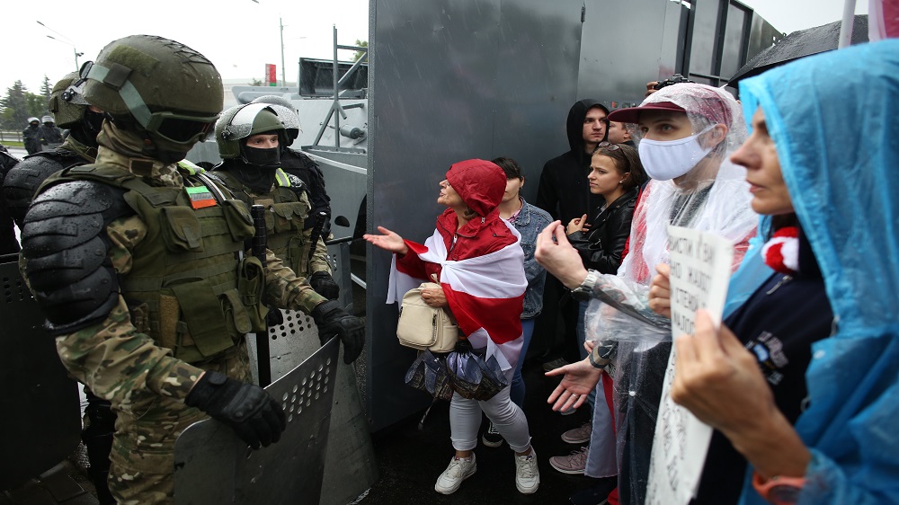 Opposition supporters speak with Belarusian troops during a rally to protest the disputed August 9 election [TUT.BY via AFP]