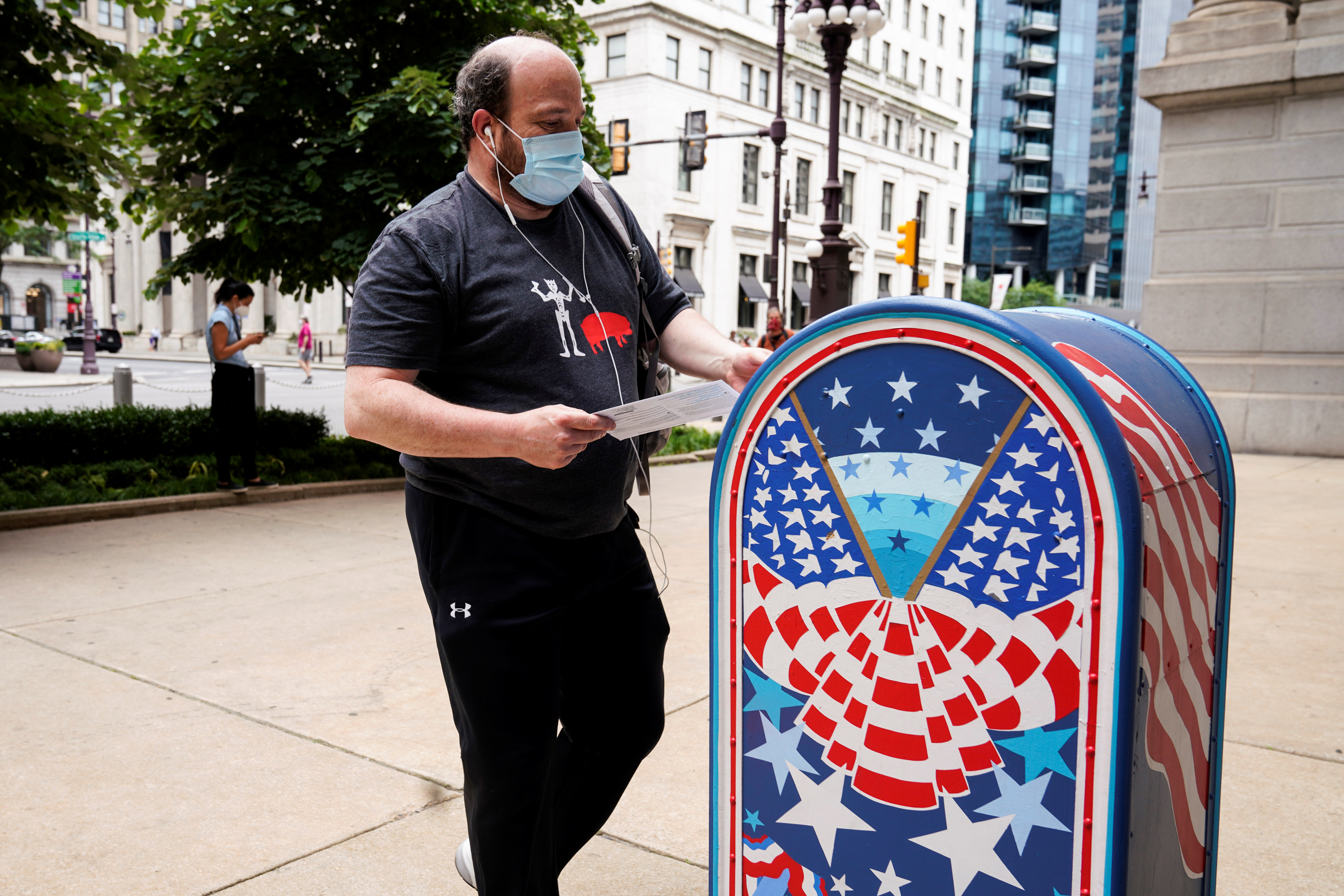 A man wearing a mask to prevent the spread of coronavirus disease (COVID-19) casts his ballot in the primary election in Philadelphia, Pennsylvania, in June