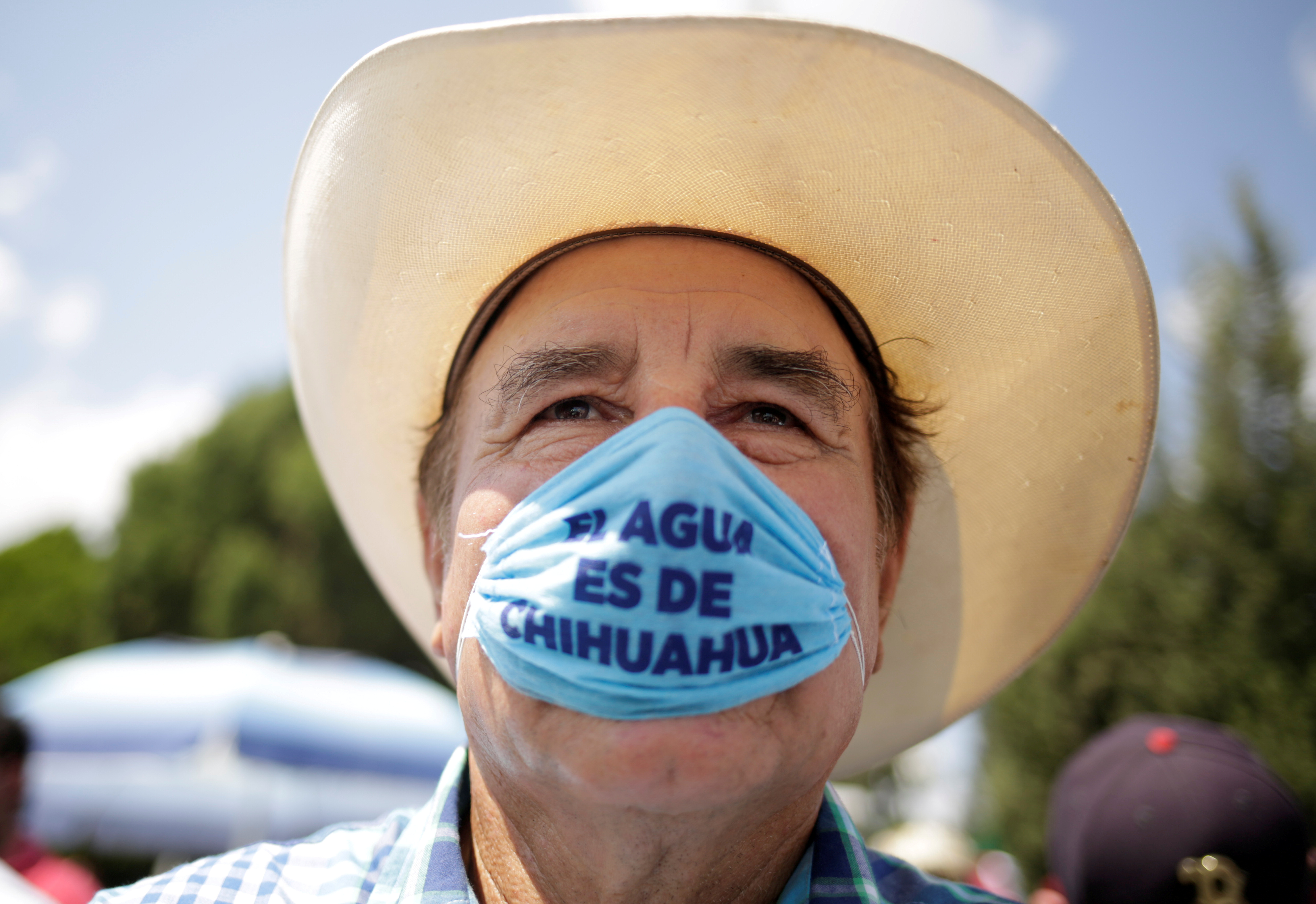 A man wearing a protective face mask that reads 'Water belongs to Chihuahua' attends a protest in Delicias, Chihuahua state, Mexico on September 20, 2020 against a Mexican government decision to divert water from La Boquilla dam to the US as part of a 1944 bilateral water treaty between the two countries [REUTERS/Jose Luis Gonzalez/File Photo]