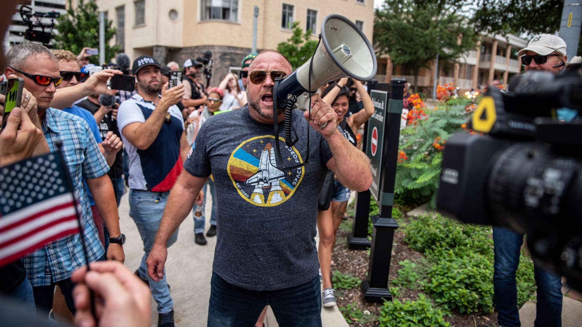Far-right conspiracy theorist and radio host Alex Jones speaks during a protest against mandates to wear masks amid the COVID-19 outbreak in Austin, Texas [Reuters]