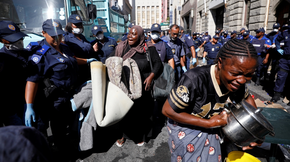 A woman wails as law enforcement officials move in to disperse a group of immigrants who had occupied an historic church and a square demanding to be moved to another country as they felt unsafe because of xenophobic attacks, in central Cape Town, on March 1, 2020