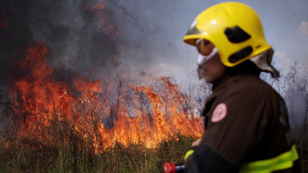 A firefighter monitors a spot fire in an area of the Amazon rainforest, near Porto Velho, Rondonia State, Brazil