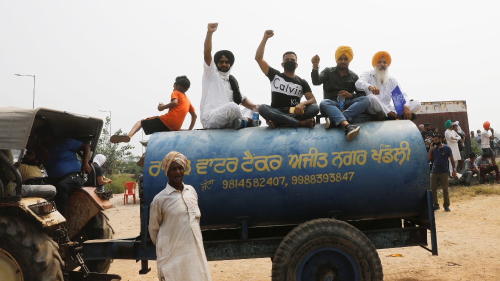 Farmers sit on a water tank as they block a national highway during a protest against farm bills passed by India’s parliament, in Shambhu in the northern state of Punjab, India, September 25, 2020