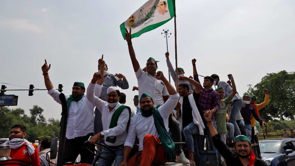 Farmers on a tractor shout slogans as they block the Delhi-Uttar Pradesh border during a protest against farm bills passed by India’s parliament, in Noida, India