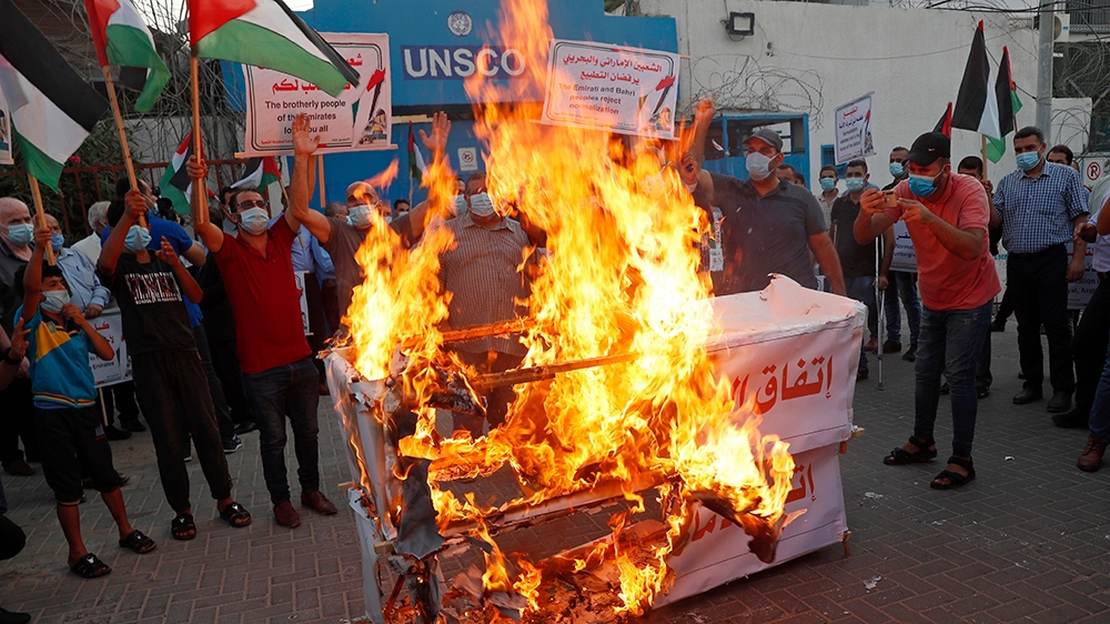 Protesters burn mock coffins of the UAE and Bahraini agreements in front of the United Nations office in Gaza City