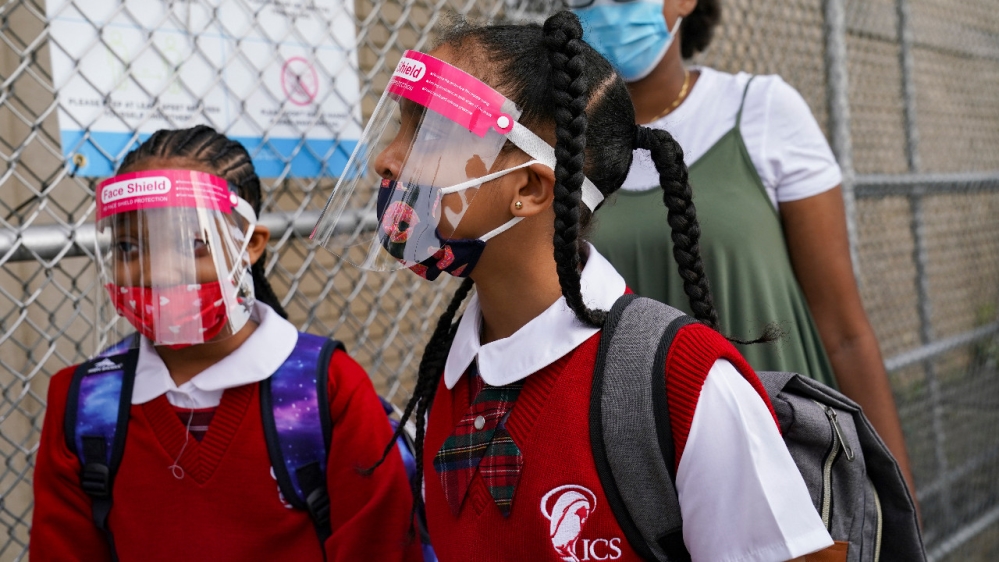 Students wear protective masks as they arrive for classes at the Immaculate Conception School while observing COVID-19 prevention protocols in The Bronx borough of New York