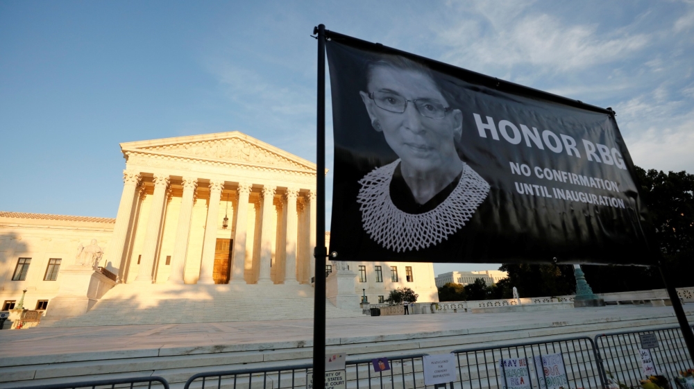 A banner with an image of the late US Supreme Court Justice Ruth Bader Ginsburg and a message referring to the selection of her successor is displayed outside the Supreme Court Yuri Gripas/Reuters]