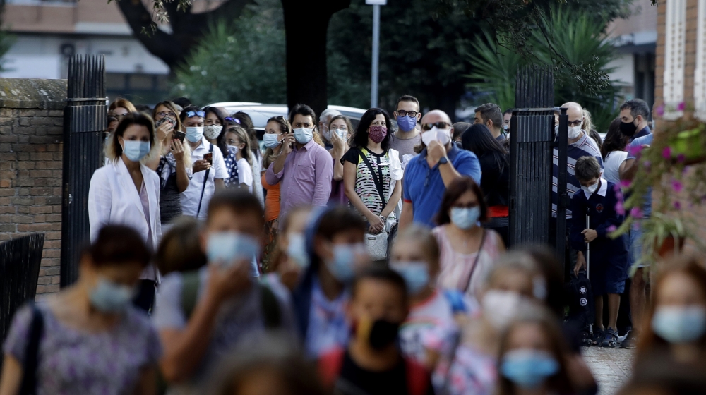 Relatives and parents look at students entering the San Policarpo parish as Italian schools reopened, in Rome, Monday, Sept. 14, 2020. Primary school