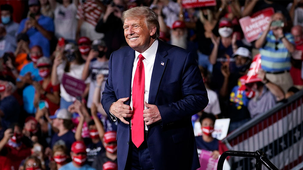 Supporters cheer as President Donald Trump speaks during a campaign rally at Smith Reynolds Airport, in Winston-Salem, North Carolina