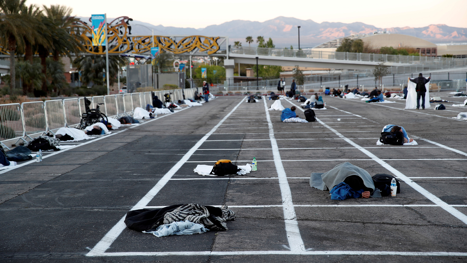 Homeless people sleep in a temporary parking lot shelter, with spaces marked for social distancing to help slow the spread of COVID-19, in Las Vegas, Nevada on March 30, 2020