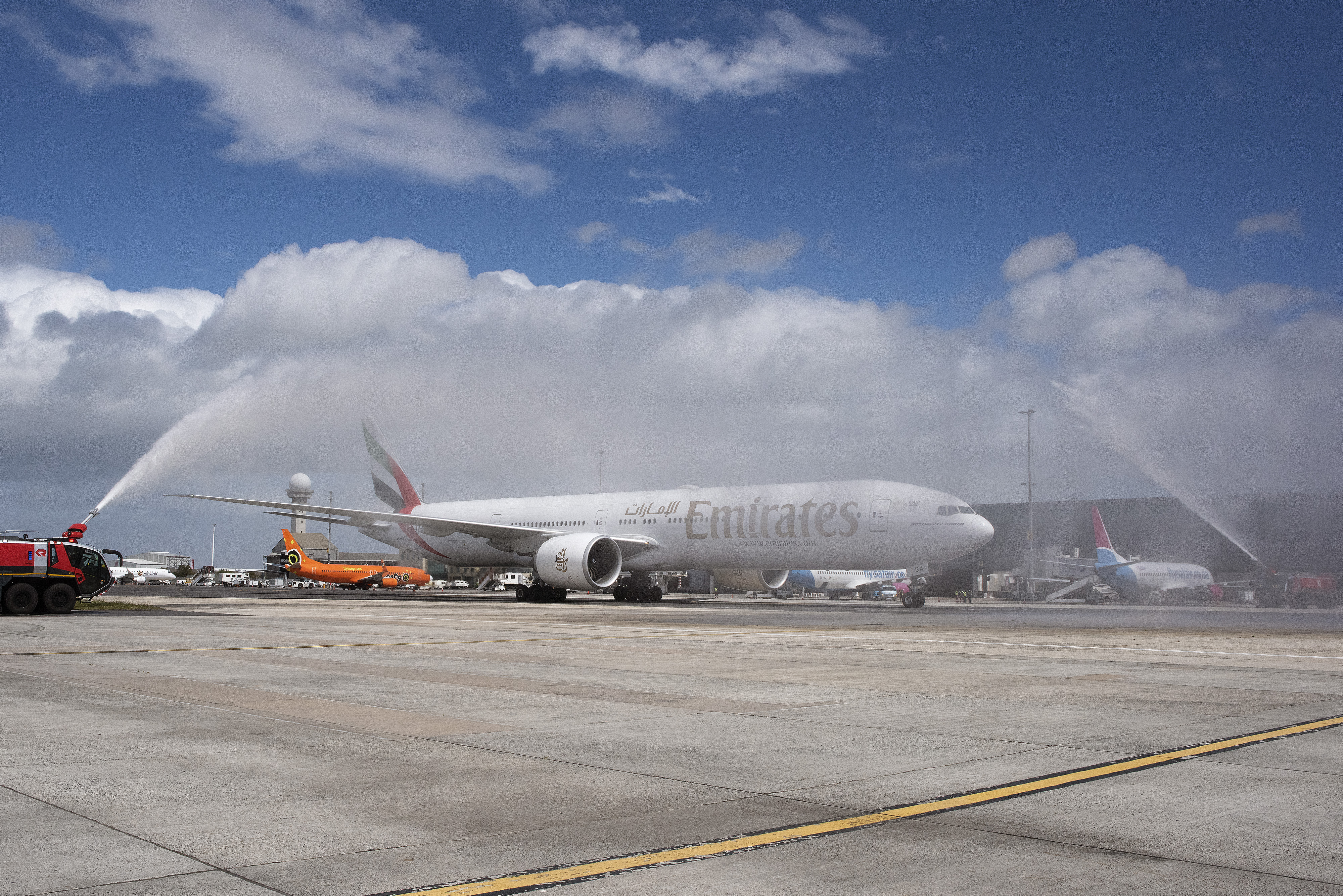 An Emirates aircraft is sprayed with water by fire-engines after landing at the Cape Town International airport after flying from Dubai