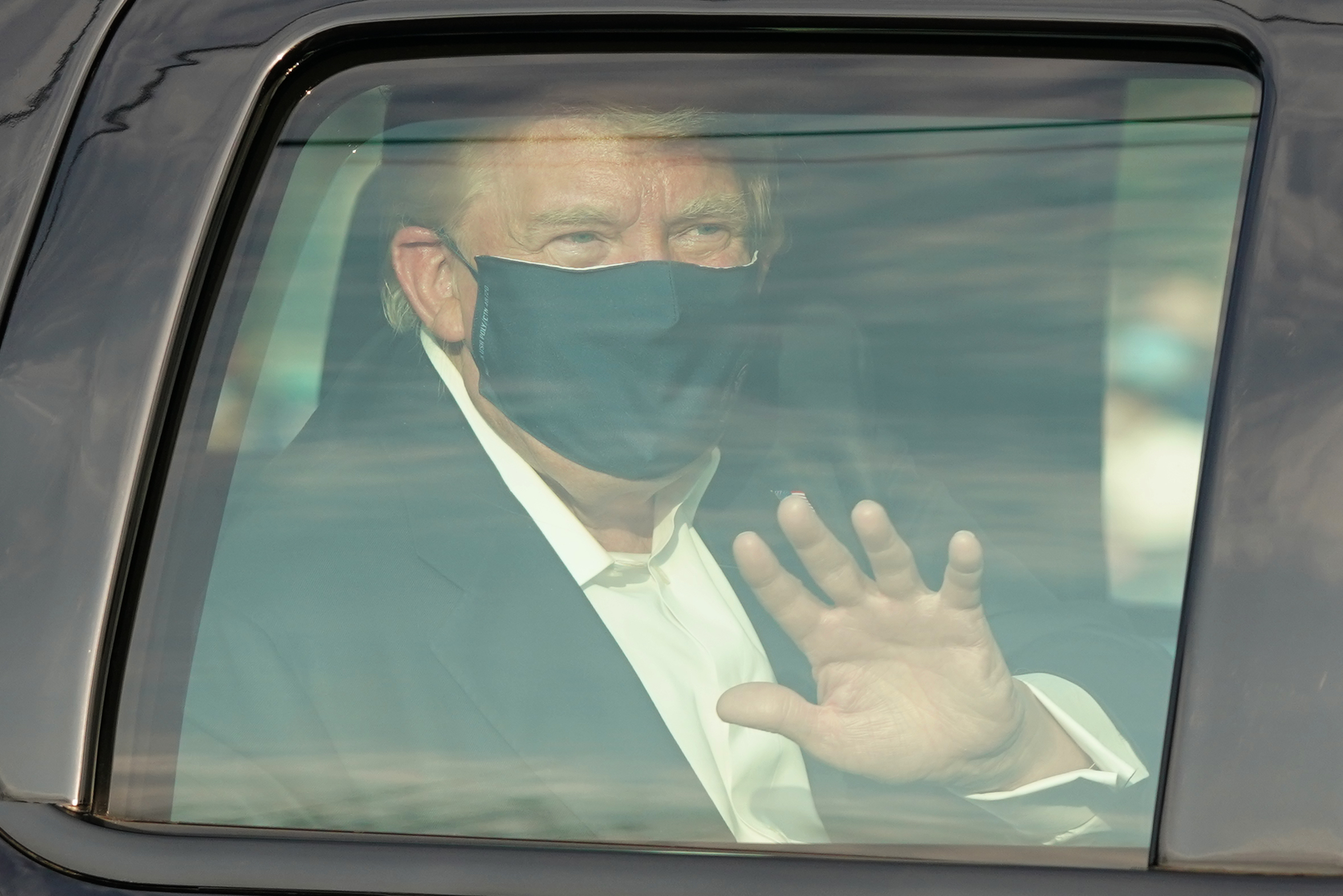 A car with US President Trump drives past supporters in a motorcade outside of Walter Reed medical centre in Bethesda, Maryland on Sunday
