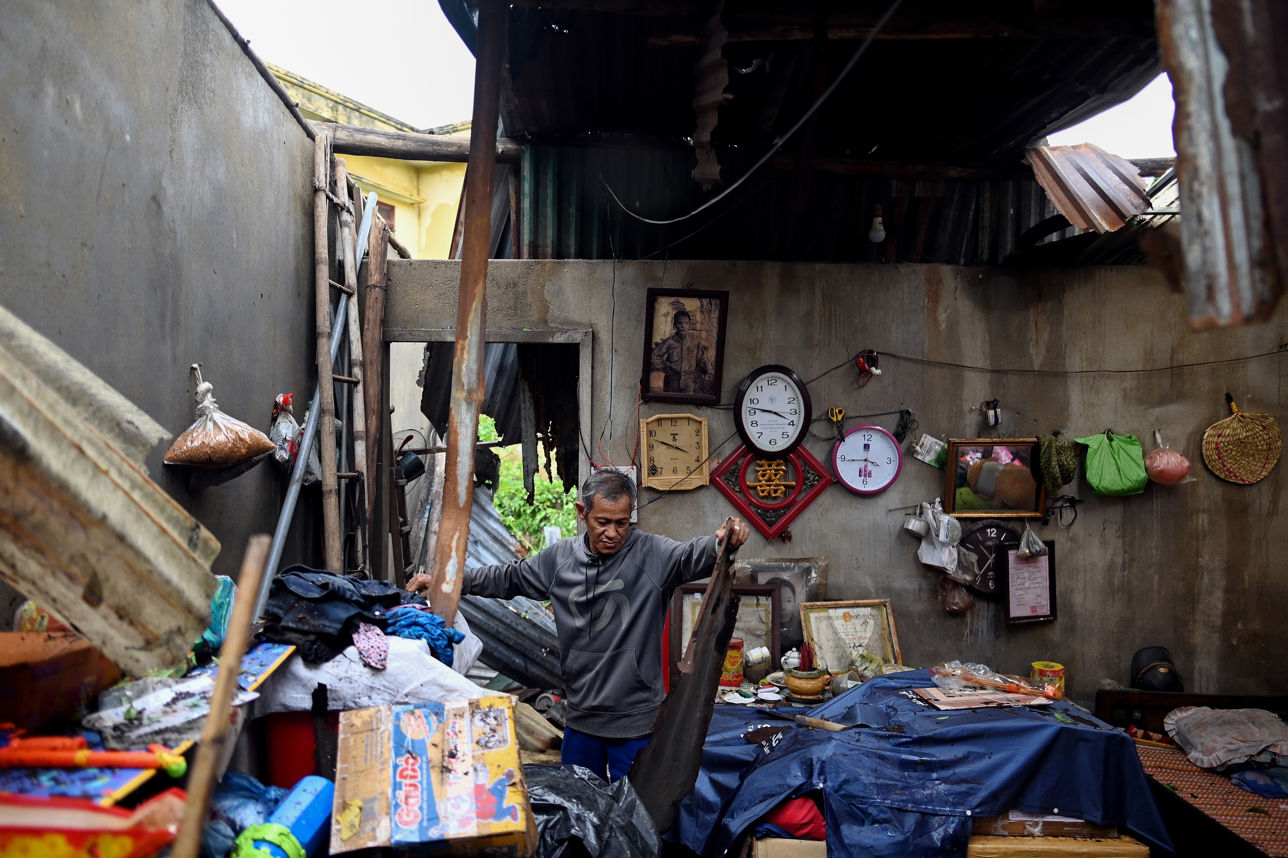 A man clears debris from inside his house after it was damaged in central Vietnam’s Quang Ngai province on October 28, 2020, following the aftermath of Typhoon Molave