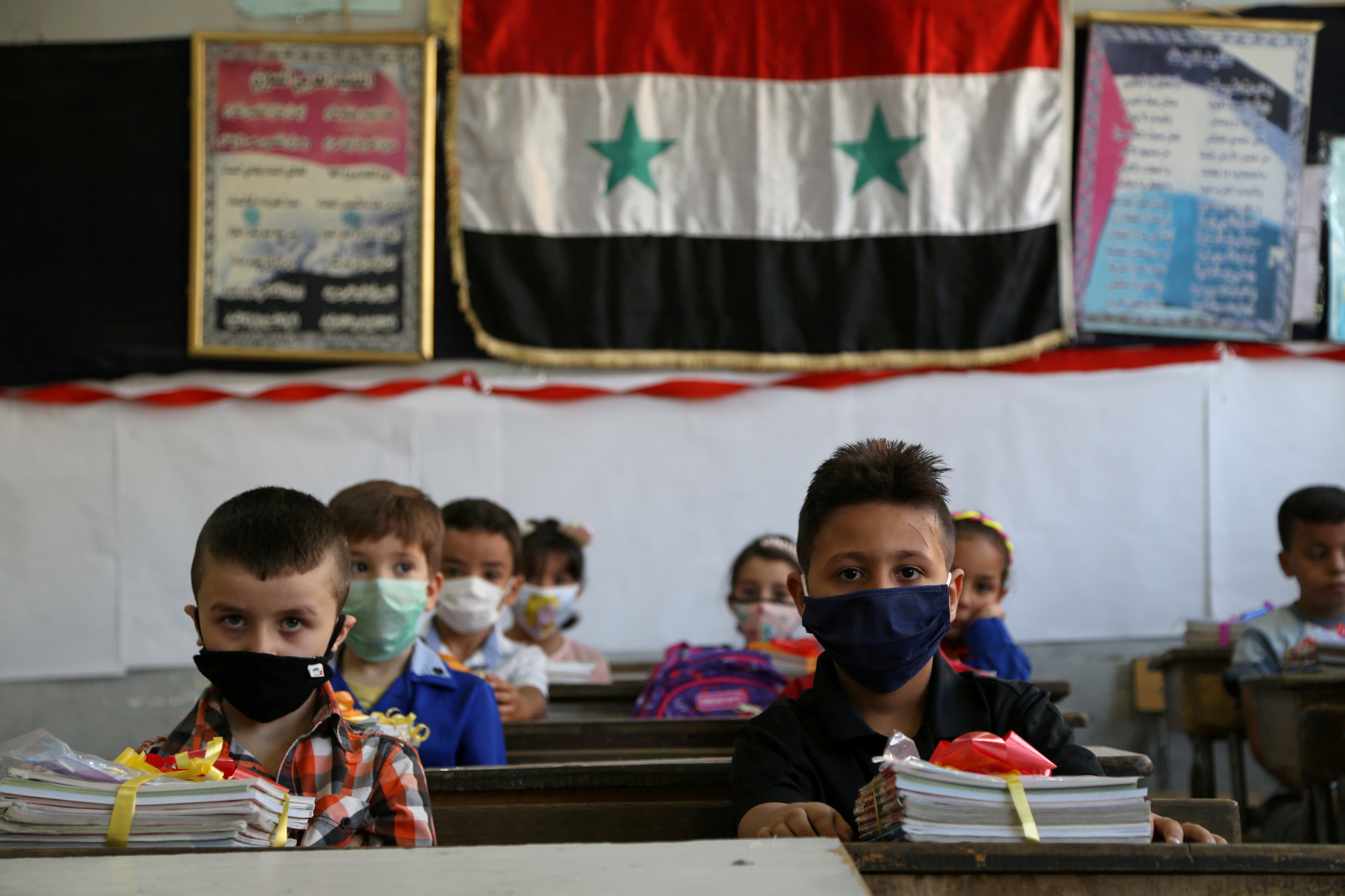 Students wearing protective face masks sit in a classroom as the school year kicks off amid concerns about the spread of the coronavirus disease, in Damascus, Syria