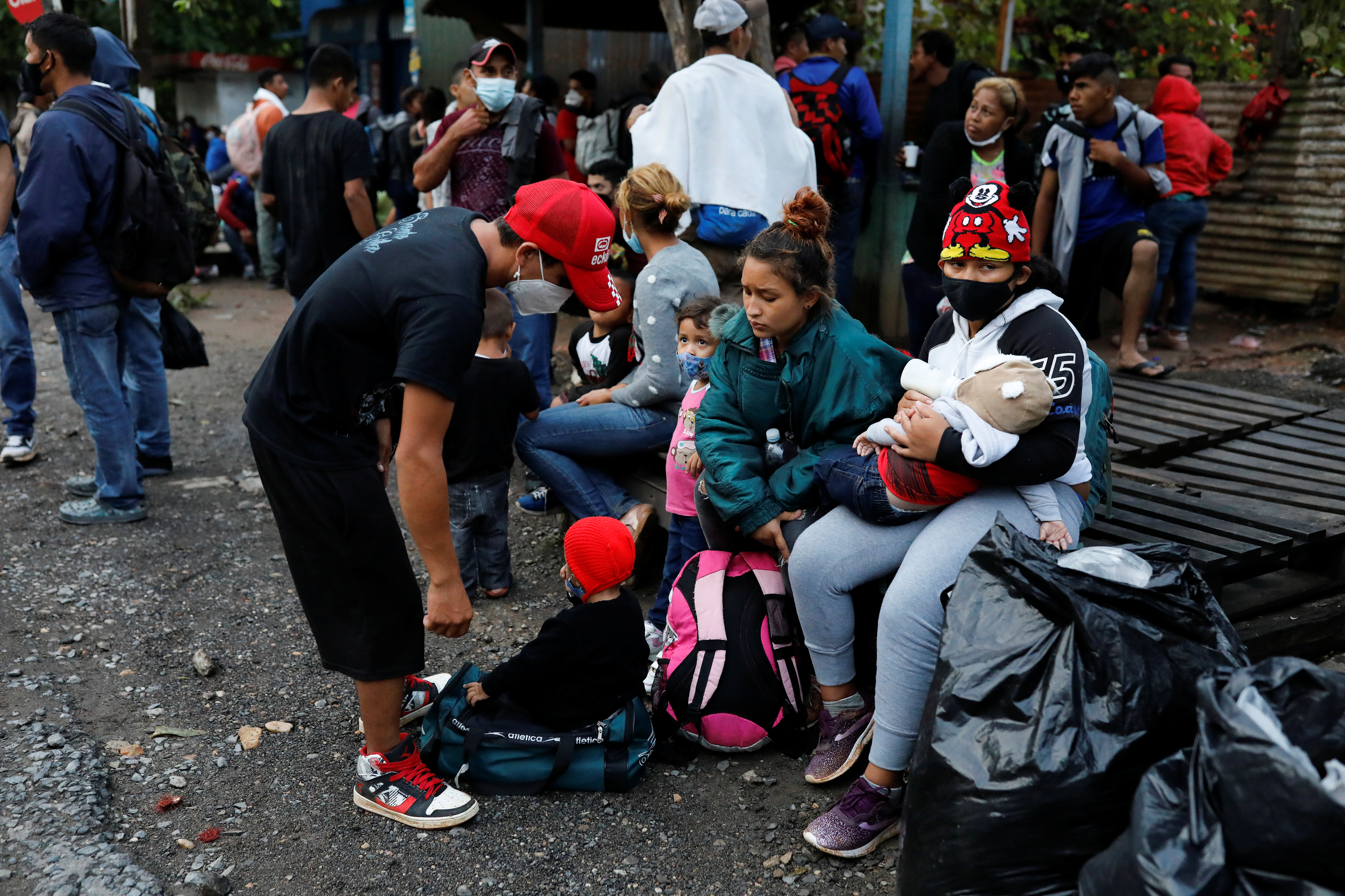 Honduran migrants rest at the Corinto border crossing checkpoint between Guatemala and Honduras, on their way home after trying to reach the US