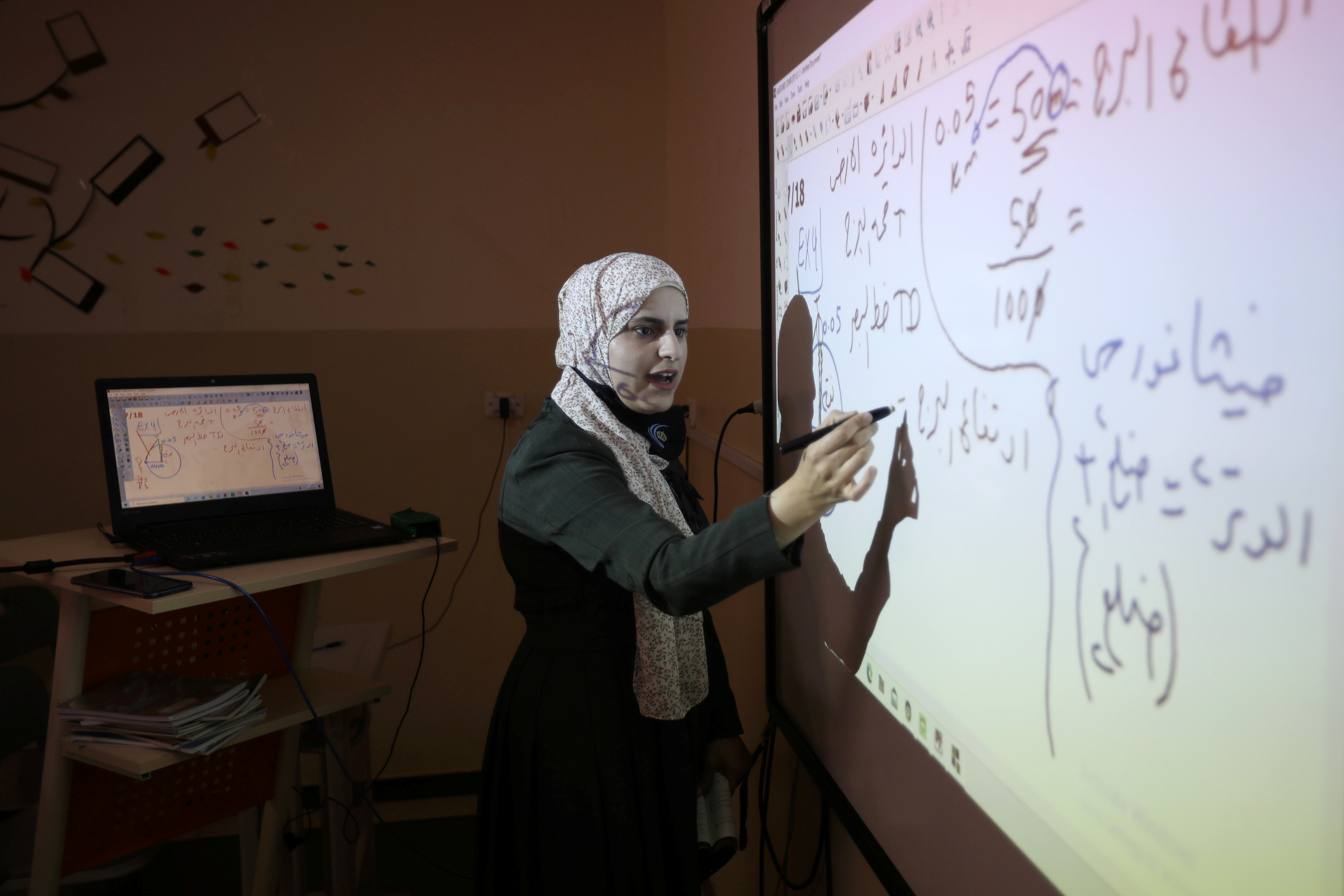 A private school teacher gives an online lesson to students receiving distance education in Amman, Jordan